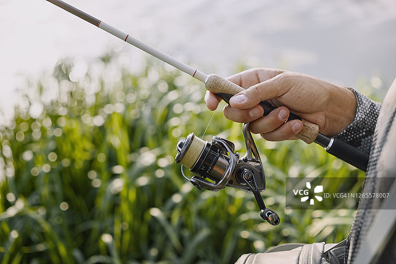 渔夫在日落时分的河边钓鱼图片素材