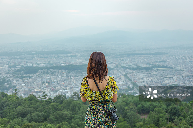 在京都山顶欣赏城市景观的亚洲女人图片素材