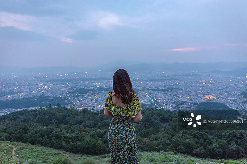 在京都山顶欣赏城市景观的亚洲女人图片素材