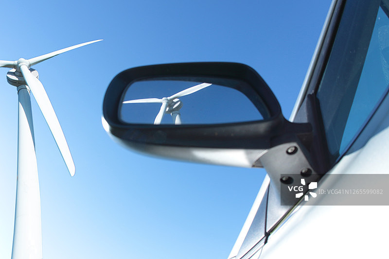 汽车后视镜中反射的风力涡轮机图片素材