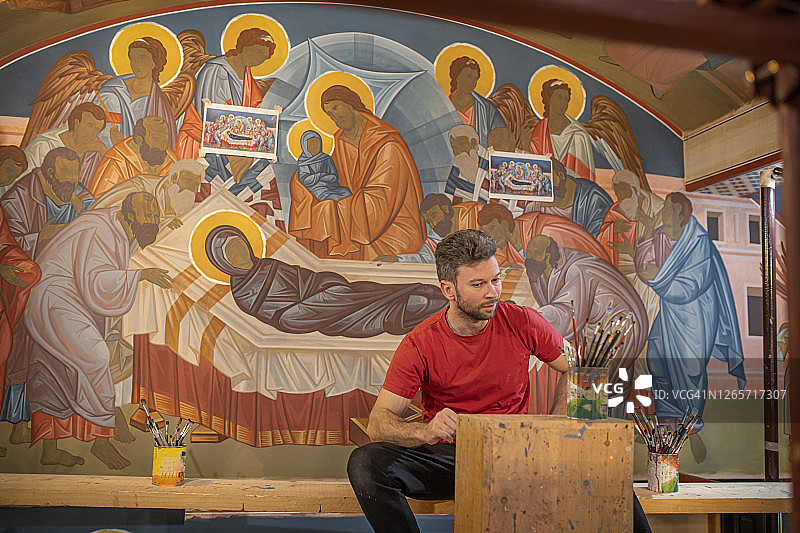 坐在教堂里寻找灵感的年轻艺术家图片素材