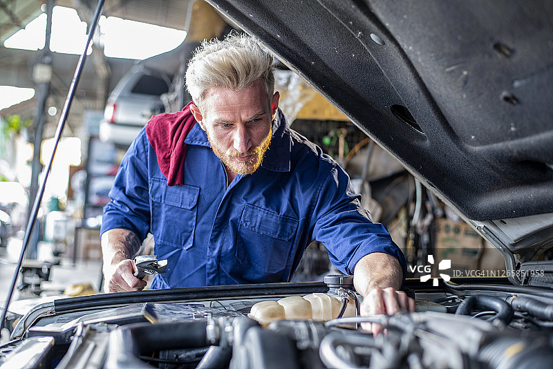 在汽车修理厂工作的修理工图片素材