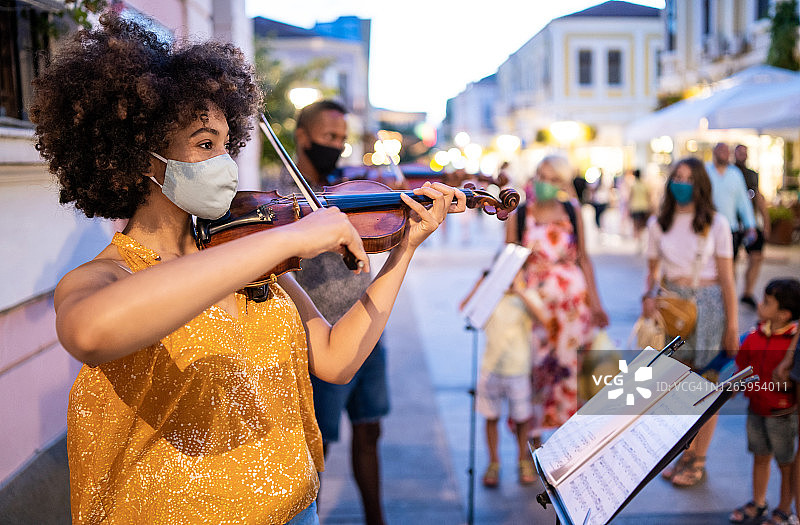疫情期间戴口罩在街头演奏小提琴的黑人音乐家图片素材