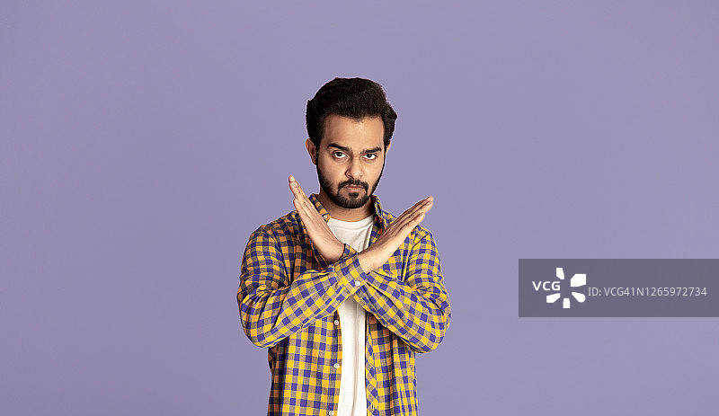 双手交叉，做出停止手势的年轻英俊印度男子图片素材