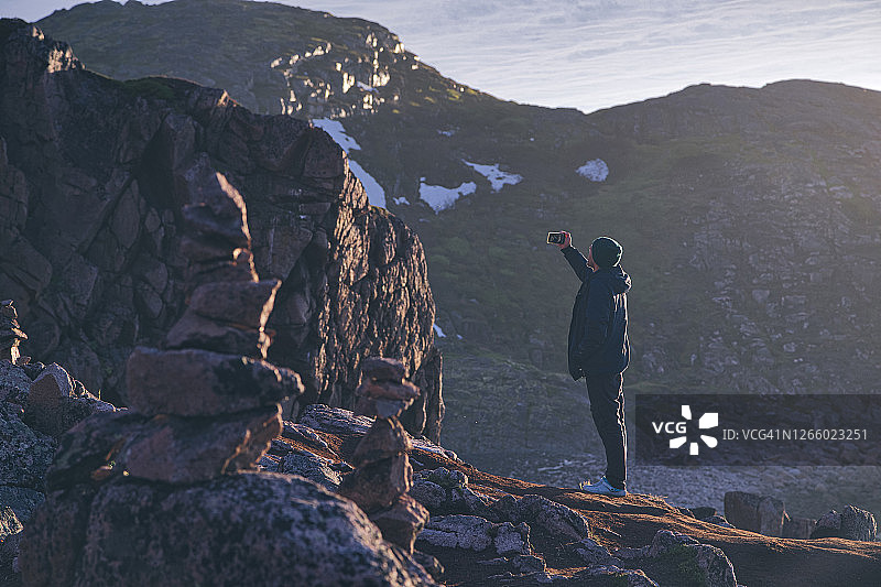 年轻人在俄罗斯摩尔曼斯克州捷里别尔卡岩山上自拍图片素材