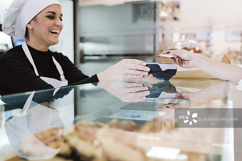 面包师接受顾客信用卡非接触式支付图片素材