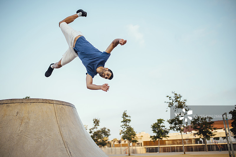 在城市中，年轻男人在空中表演特技跳跃图片素材