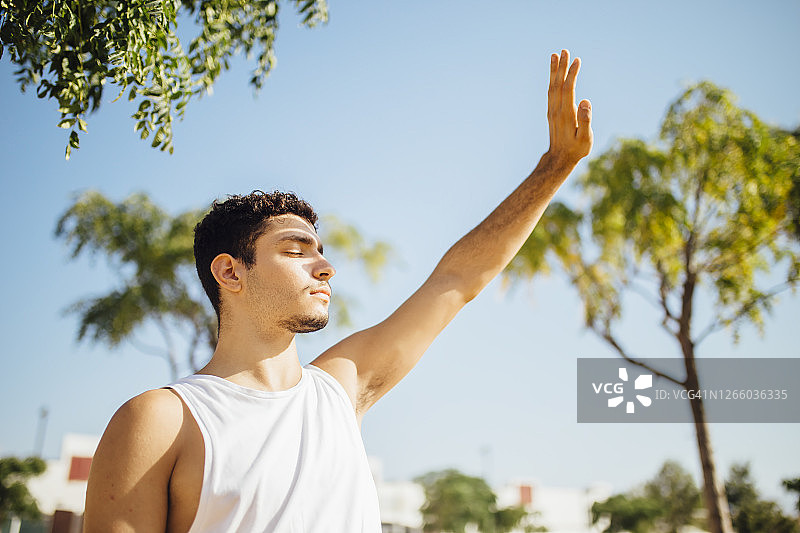 在晴朗的白天遮住眼睛的年轻男人图片素材