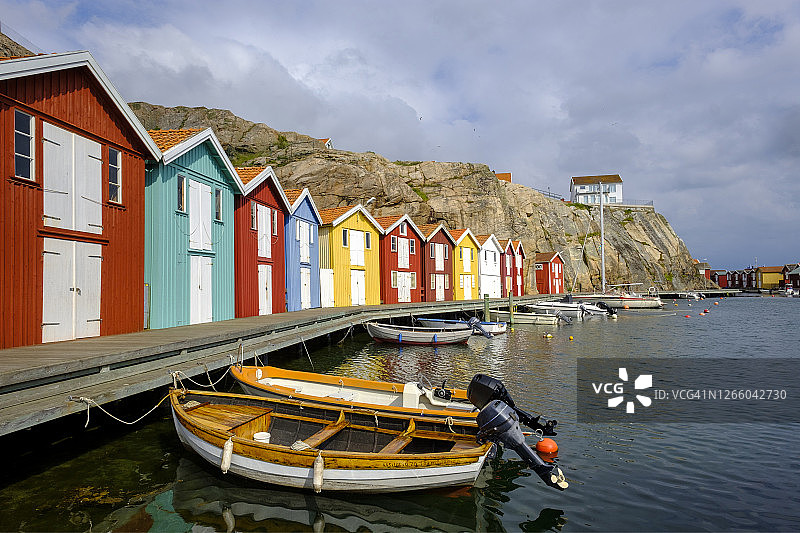 瑞典西约塔兰省斯莫根：停泊在彩色船屋前的船只图片素材