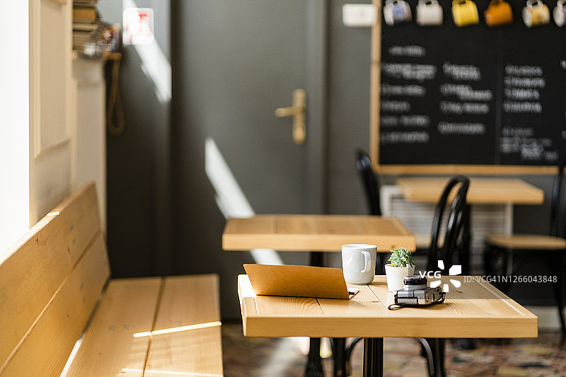 现代咖啡店木桌上的书籍和相机图片素材