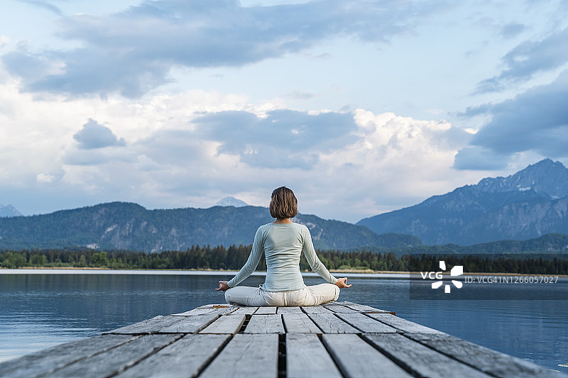 中年女人在多云的天空下冥想图片素材