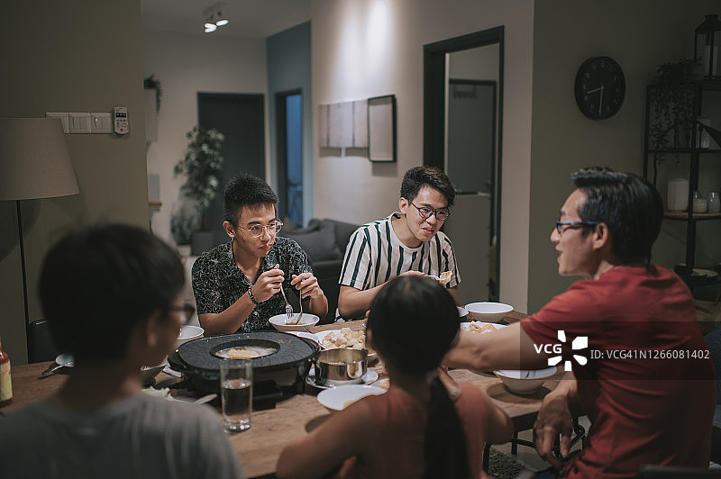 中国家庭和朋友在家中聚餐，享用传统中式火锅图片素材