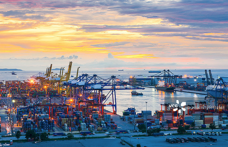 起重机和工业货船在港口黄昏背景图片素材