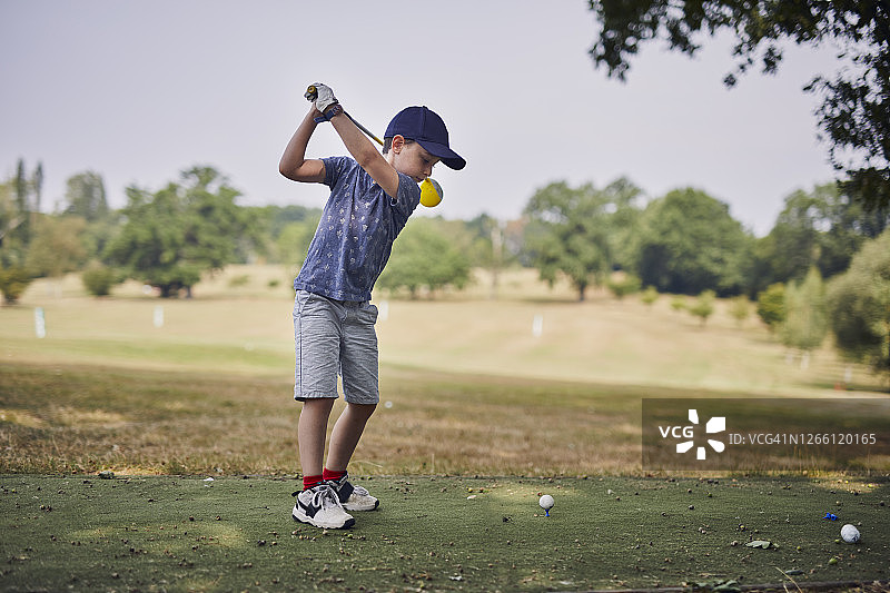 在伦敦俱乐部打高尔夫的7岁男孩图片素材