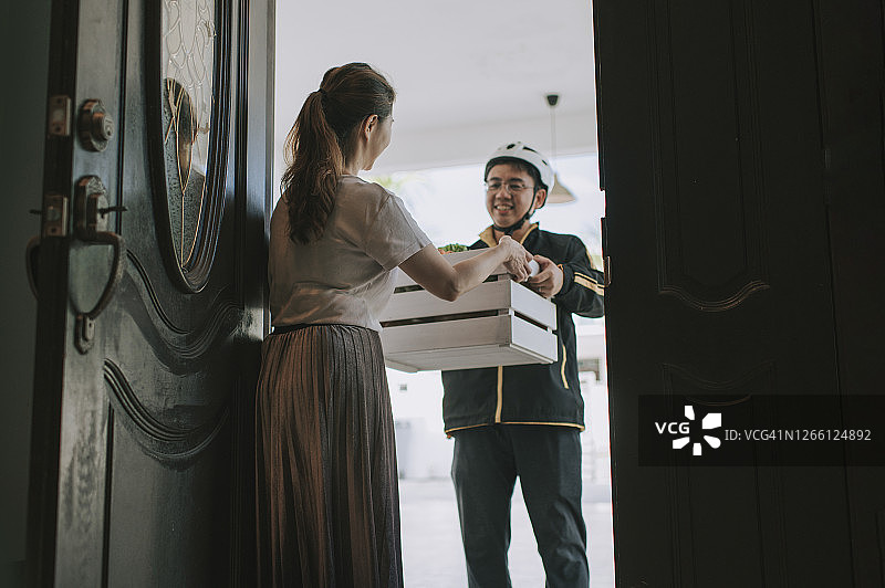 中国男性送货员为顾客配送蔬菜图片素材