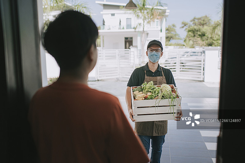 一位亚洲华人男性给他的客户送菜图片素材