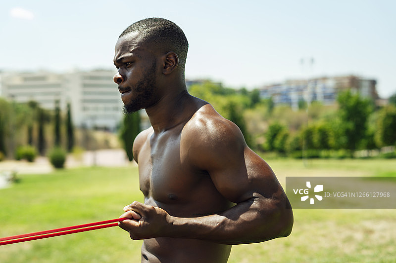 年轻运动员用橡皮筋做肱二头肌练习图片素材