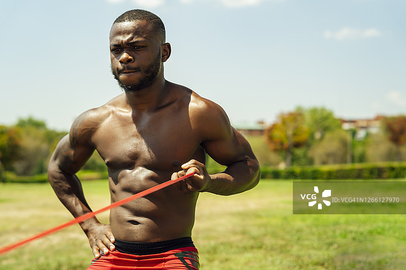 年轻运动员用橡皮筋做手臂运动图片素材
