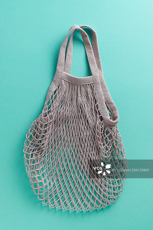 可重复使用的环保购物袋，由可回收材料制成的网兜，绿色背景图片素材