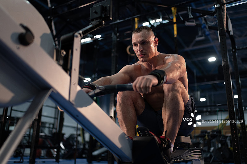 运动男士在划船机上锻炼图片素材