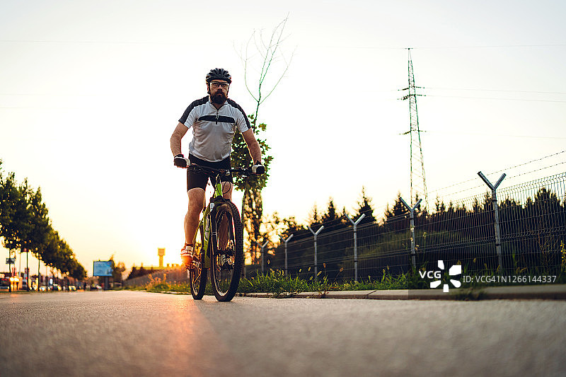 骑行者在日落的路上图片素材