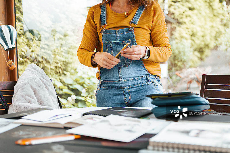 女艺术家在工作室用彩色铅笔绘画图片素材