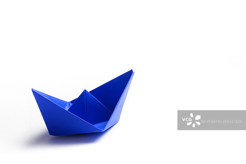 白色背景上的蓝色纸船图片素材