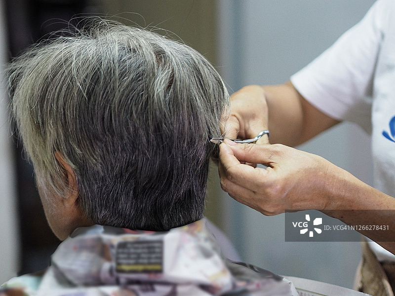 居家隔离的母亲在剪白发图片素材