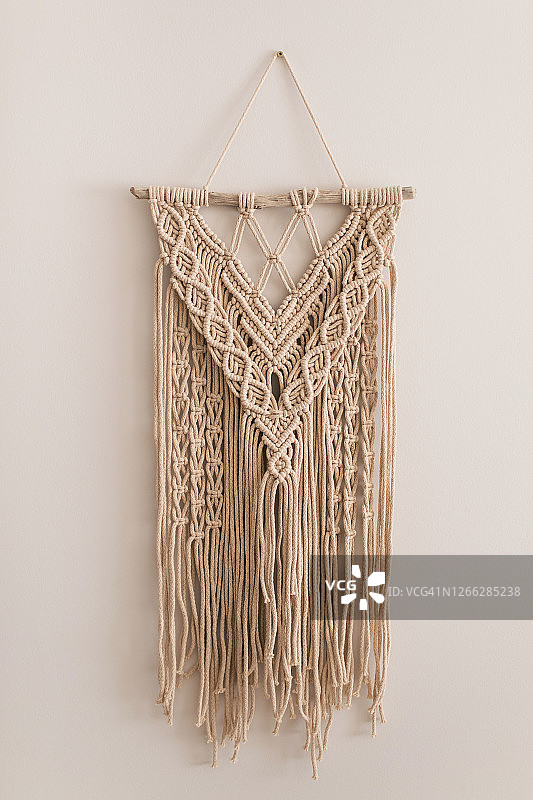 米色墙上手工天然棉质流苏装饰品，时尚环保家居饰品图片素材