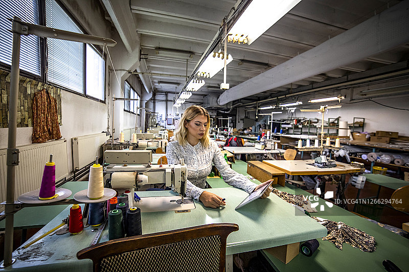 纺织业厂长在工厂工作，控制质量并创造新产品图片素材