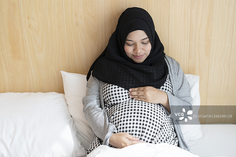 快乐的穆斯林年轻孕妇充满爱意地等待孩子图片素材