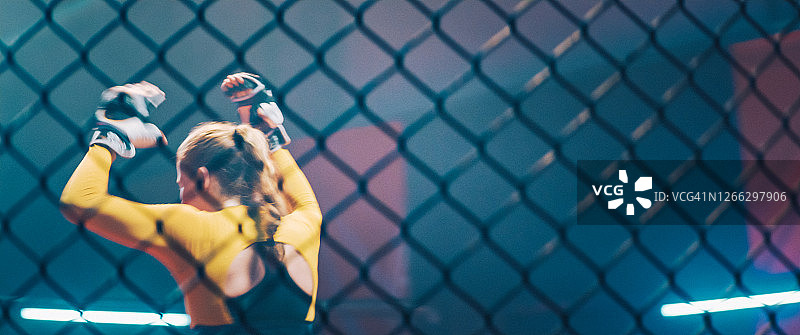 庆祝胜利的女性格斗者，欢呼并举起手臂图片素材