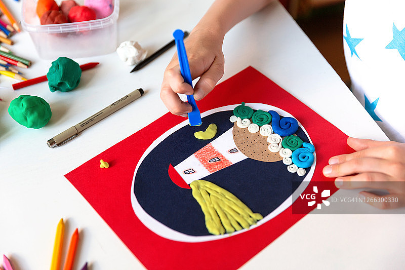孩子用彩色纸和橡皮泥进行手工创作图片素材