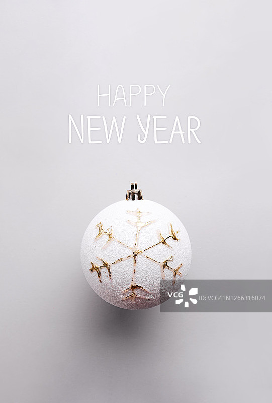 带有白色圣诞球的圣诞贺卡，白色圣诞球上挂着金色饰品，背景为灰色图片素材