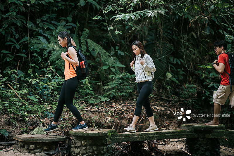 三位亚洲朋友在雨林中徒步旅行图片素材
