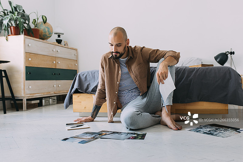 摄影师在卧室处理照片，在家工作概念图片素材