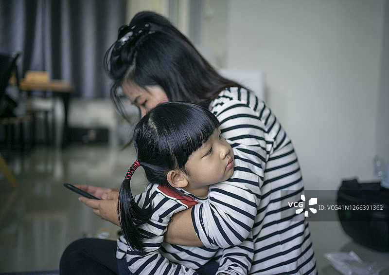 亚洲家庭（父亲、母亲和女儿）在家玩电子游戏图片素材