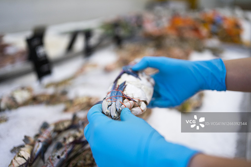 女人戴手术手套在超市购买新鲜食物图片素材