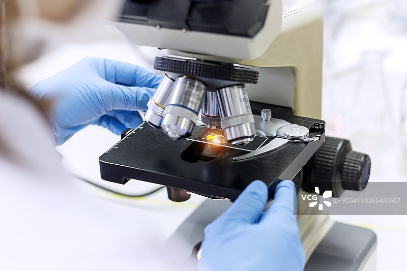 实验概念：科学家在医学研究中使用显微镜的特写照片图片素材