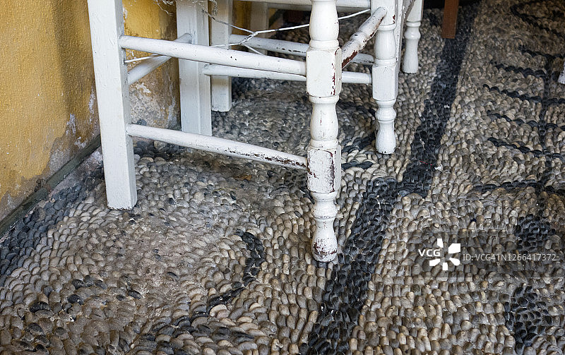 希腊土耳其咖啡馆或酒吧内的木椅，地面铺有鹅卵石图片素材