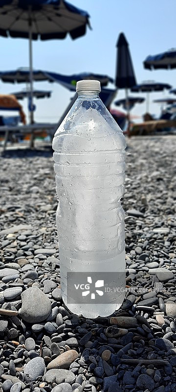 炎热沙滩上的冰镇瓶子图片素材