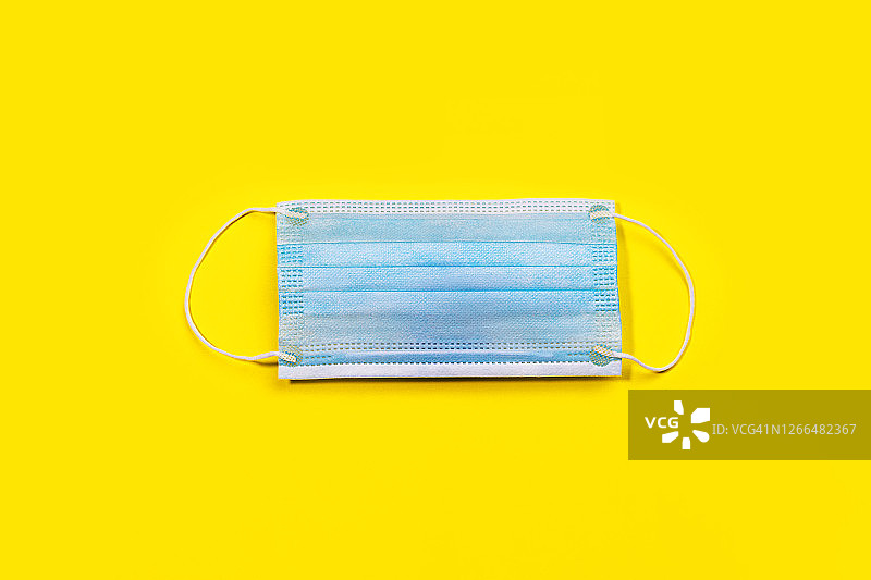 黄色背景上的医用口罩图片素材