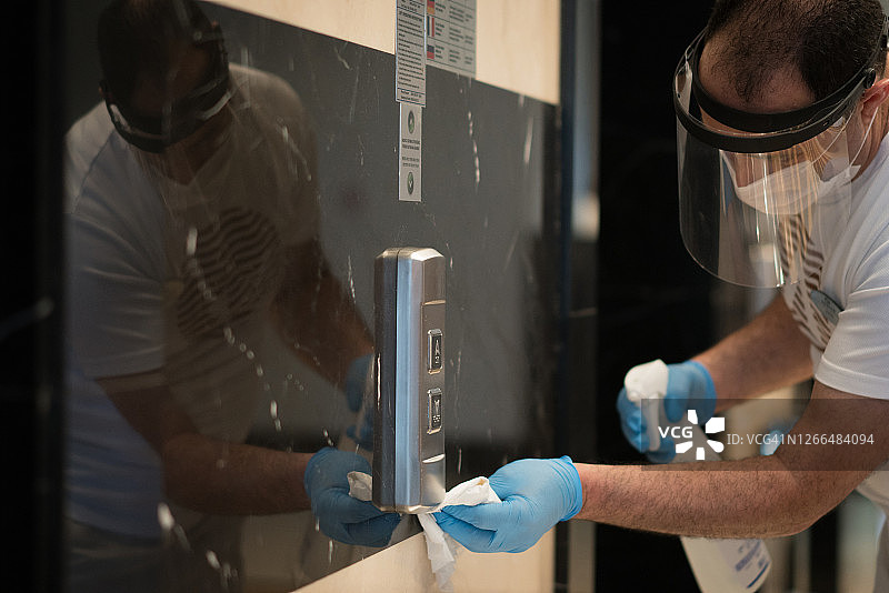 酒店员工擦拭电梯内部以预防新冠图片素材