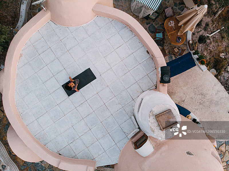 女子在家中露台练习瑜伽鸟瞰图图片素材