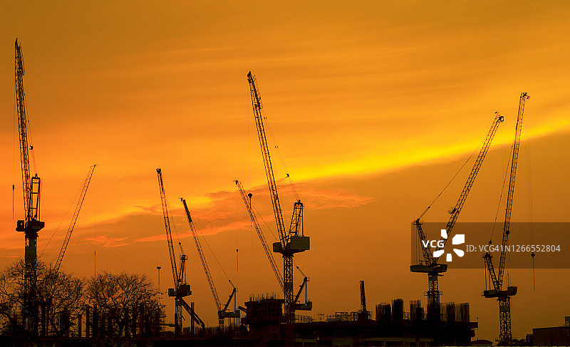日出时分的工业建筑起重机和建筑轮廓图片素材