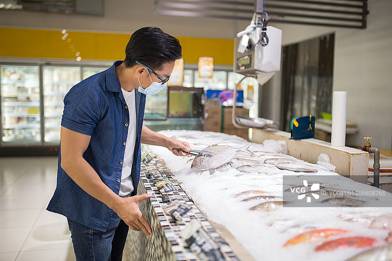 在商店选择海鲜的亚洲中年男人图片素材