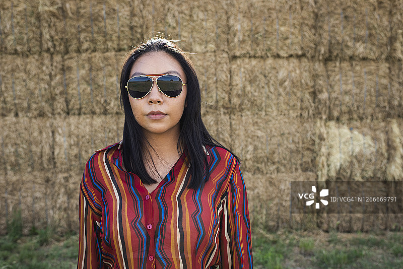 年轻女人站在干草堆旁图片素材