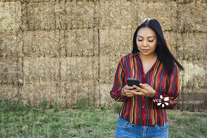 在户外使用手机的年轻女人图片素材