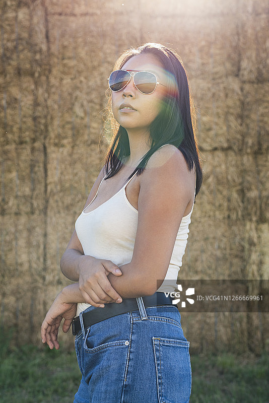 年轻女人站在干草堆旁图片素材