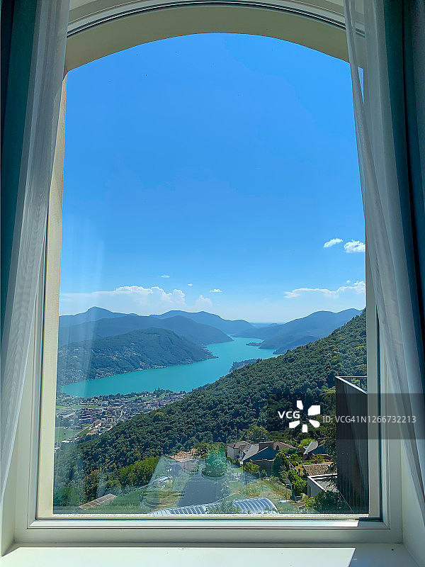 阿尔卑斯湖和山脉的窗外景色图片素材